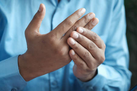 man suffering pain in hand close upの写真素材