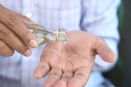 pouring hair oil on hand close upの写真素材