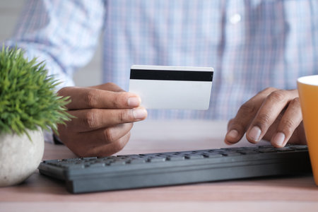 man hands holding credit card and using laptop shopping online