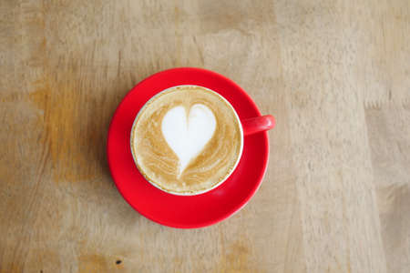 a cup of late coffee with flower shape design on top at cafeの写真素材