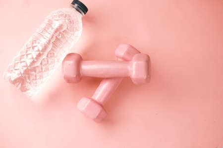 Fitness concept with dumbbell and bottle on white desk.の写真素材
