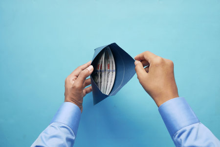 person hand putting cash in a envelope.