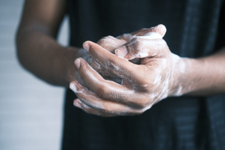 young man washing hands with soap warm water