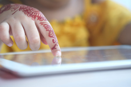 child hand pointing finger on digital tablet screen.