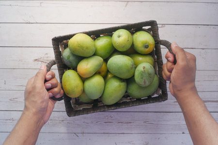 Fresh green mango in a bowl on table