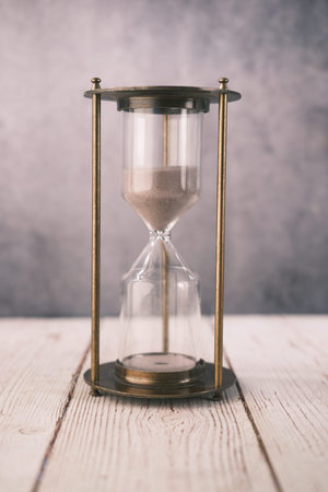 hourglass on table, sand flowing through the bulb of sandglassの写真素材