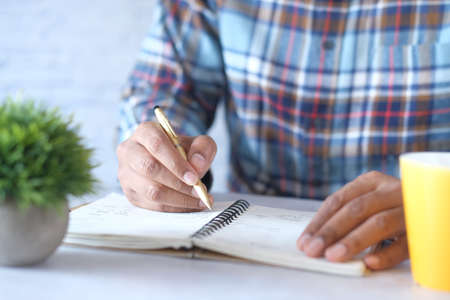 Close up of man hand writing on notepad.の写真素材