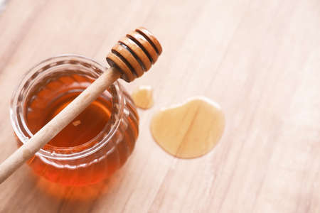 close up of fresh honey with spoon on tableの写真素材