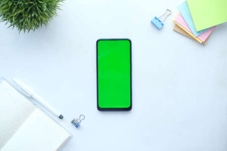 top view of smart phone and notepad on white backgroundの写真素材