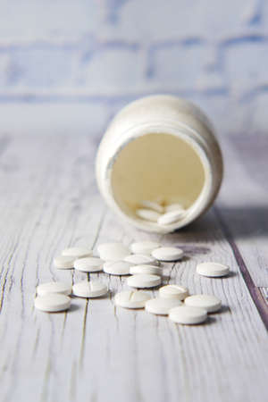 white color medical pills spilling on tableの写真素材