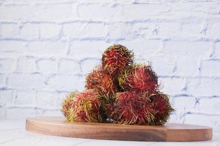stack of rambutan in a chopping board on table