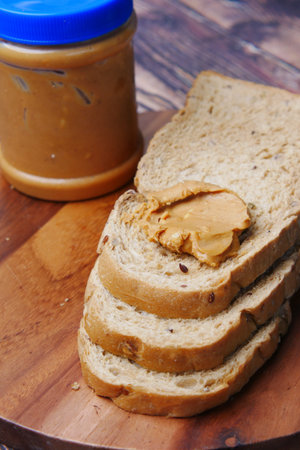 top view of peanut butter and stack of bread on table