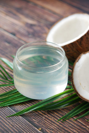 slice of fresh coconut and bottle of oil on a tableの写真素材