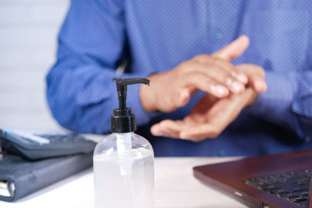 businessman using sanitizer gel on on office desk