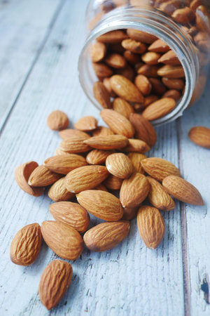 Close up of almond nut spilling from a containerの写真素材