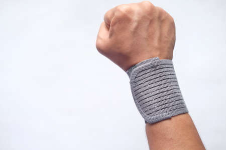hand with wrist support against blue background.の写真素材