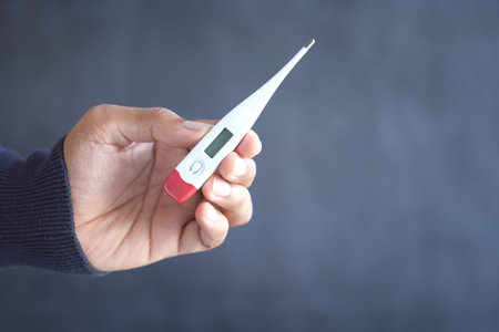 close up of man hand holding digital thermometer.