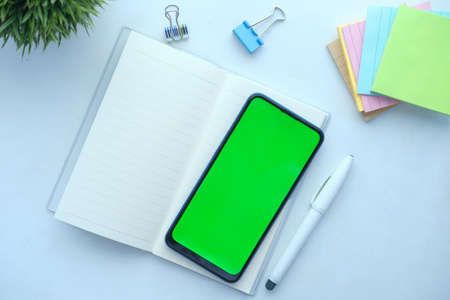 top view of smart phone and notepad on white backgroundの写真素材