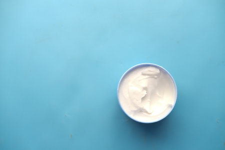 f beauty cream in a container on blue backgroundの写真素材