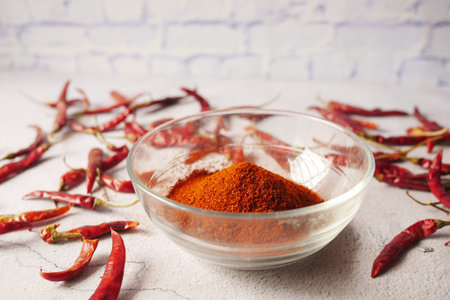 Chili powder and red peppers on table background.の写真素材