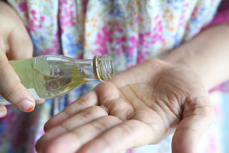 pouring hair oil on hand close upの写真素材