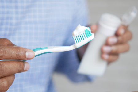 hand holding tooth brush with paste
