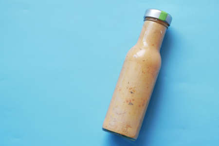 Fresh organic mustard in a bottle on blue backgroundの写真素材