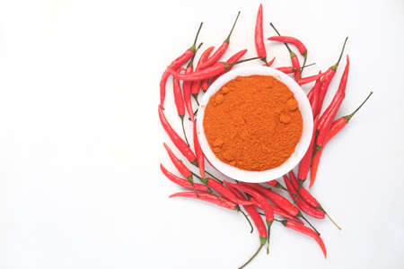 Chili powder and red peppers on white background.の写真素材