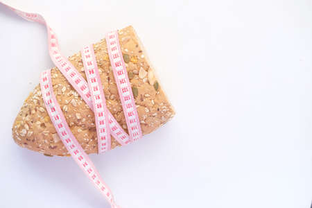 slice of whole meal bread and measurement tape on table .の写真素材