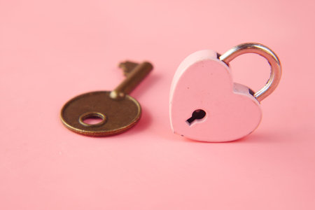 Pink Heart Shape Padlock And Key on tableの写真素材