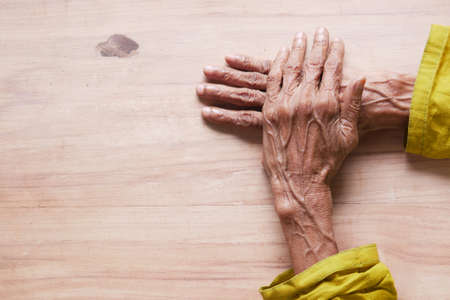 hands of a elderly person on tableの写真素材