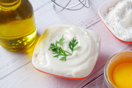 Mayonnaise in container , oil and eggs on tableの写真素材