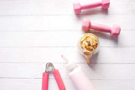 Home Made Musli in a bowl and dumbbell on tableの写真素材