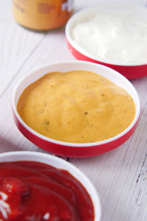 close up of Mustard, mayonnaise and sauce in a container on table .の写真素材