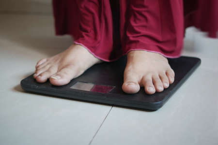womans feet on weight scale close up.の写真素材