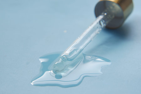 Drop falls from a pipette on flat surfaceの写真素材