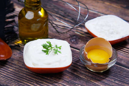 Mayonnaise in container , oil and eggs on tableの写真素材