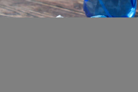 hand in blue rubber gloves cleaning table with clothの写真素材