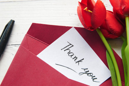 thank you message and envelope on wooden tableの写真素材