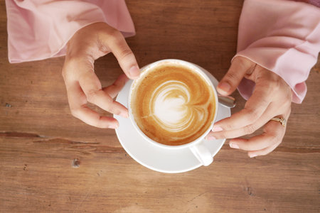 high angle view of women holding coffee cup.