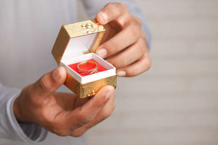 young man hold a wedding ring in a boxの写真素材
