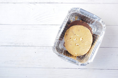 close up of sweet cookies in take away box on wooden table