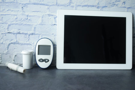 top view of digital tablet and diabetic measurement tool on table