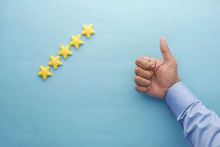 Customer review concept. Rating golden stars on blue backgroundの写真素材