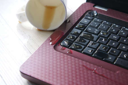 coffee spilling on laptop keyboard. close upの写真素材