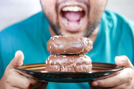 young man eating donut , selective focusの写真素材