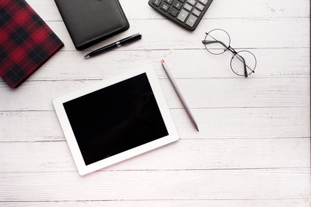 Flat composition of digital tablet and office stationary on black background
