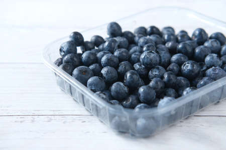 Close up of fresh blue berry in a plastic container on tableの写真素材