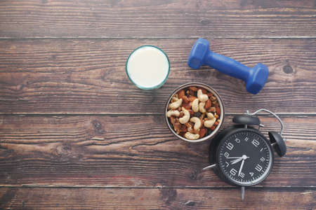 mixed nut in a bowl, milk and dumbbell on tableの写真素材
