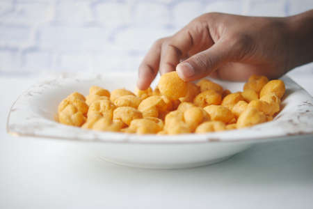 hand pick potato chips on wooden background .の写真素材